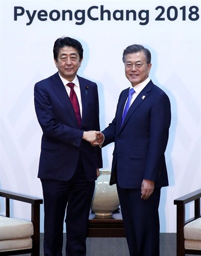 문재인 대통령이 평창올림픽 개막식이 열리는 9일 오후 강원도 용평 블리스힐스테이에서 아베 신조 일본 총리와 만나 악수하고 있다.