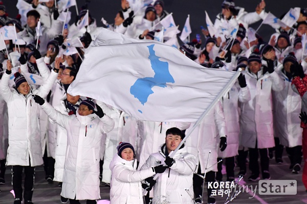  2018년 2월 9일 오후 강원도 평창 올림픽 스타디움에서 열린 2018 평창동계올림픽 개회식에서 'KOREA' 피켓과 한반도기를 앞세운 남북 선수들이 공동입장하고 있다.