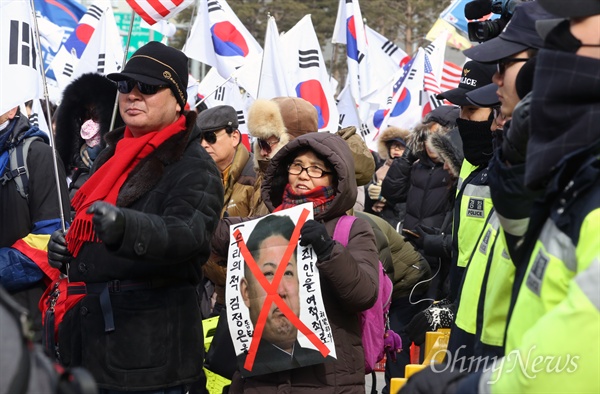 박근혜 전 대통령 지지자들이 11일 오후 서울 동대문디자인플라자 광장에서 '평양올림픽' 반대 집회를 열고 김정은 북한 노동당 위원장 사진에 'X'자를 그려 들어보이고 있다.