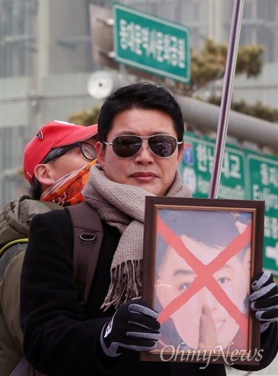 신동욱 공화당 총재가 11일 오후 서울 동대문디자인플라자 광장에서 열린 '평양올림픽' 반대 집회에 참석해 '김일성 가면' 소동을 일으킨 해당 사진을 들고 서 있다.  