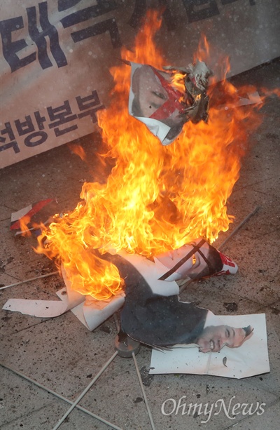 조원진 대한애국당 대표 등 박근혜 전 대통령 지지자들이 11일 오후 서울 동대문디자인플라자 광장에서 '평양올림픽' 반대 집회를 열고 김정은 북한 노동당 위원장 사진과 인공기를 불태우고 있다.