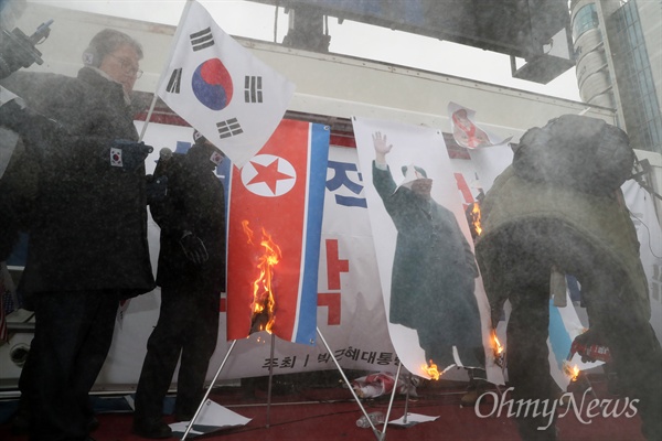 불태워지는 김정은 사진과 인공기 조원진 대한애국당 대표 등 박근혜 전 대통령 지지자들이 11일 오후 서울 동대문디자인플라자 광장에서 '평양올림픽' 반대 집회를 열고 김정은 북한 노동당 위원장 사진과 인공기를 불태우고 있다.
