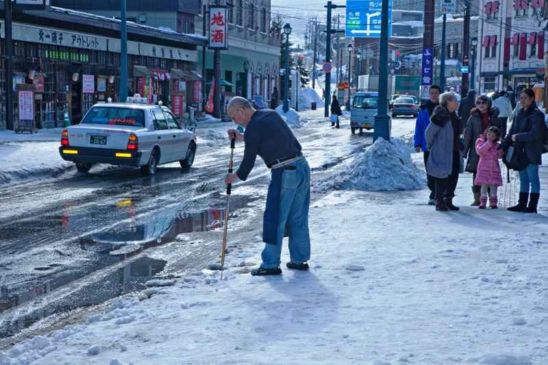 눈 내린 거리를 오가는 삿포로 시민들.