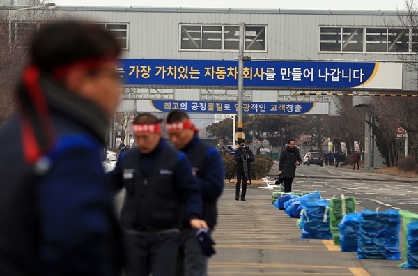 한국GM이 전북 군산공장 폐쇄를 결정했다는 소식이 알려진 14일 오전 민주노총 금속노조 전북지부 조합원들이 투쟁 머리띠를 두르고 공장 동문으로 출근하고 있다.