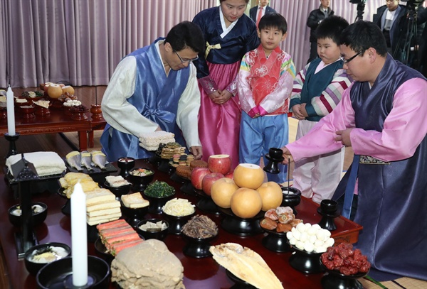 2일 오전 서울 종로구 한국전통음식연구소에서 열린 '한국농수산식품유통공사(aT)와 함께하는 설 차례상 차리기'에서 한복을 입은 가족이 차례 시연을 하고 있다