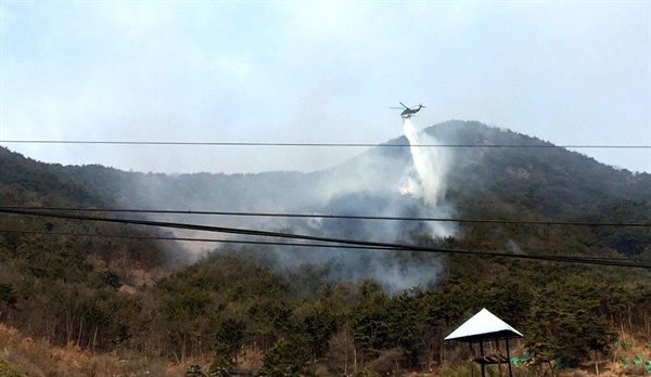 18일 오전 창원 의창구 북면 신목마을 산에서 화재가 발생해 헬기가 동원되어 진화작업이 벌어지고 있다.