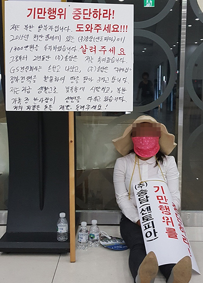 지난해 7월 천안풍세주택조합 임시총회장 앞에서 1인 시위를 벌이고 있는 탈북여성. /사진제공=우리들신문