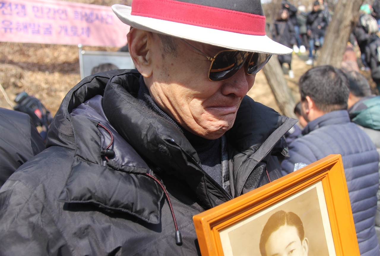 22일 오전 11시 30분, 1950년 한국전쟁 당시 경찰과 치안대에 의해 부역혐의로 불법 살해된 아산지역 희생자에 대한 유해발굴이 시작됐다. 당시 아버지를 잃은 김광욱 유족회원(왼쪽)이 아버지 사진을 들고 흐느끼고 있다.