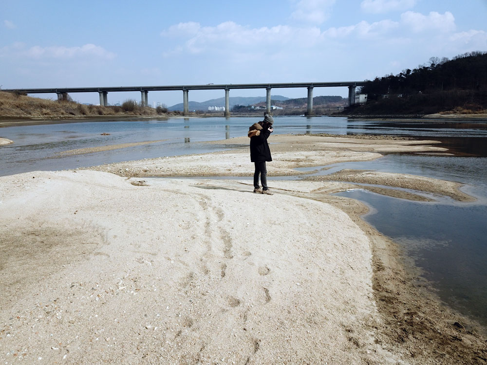 대전·당진 간 고속도로 밑 드러난 모래톱에서 이용희 활동가가 사진을 찍고 있다.