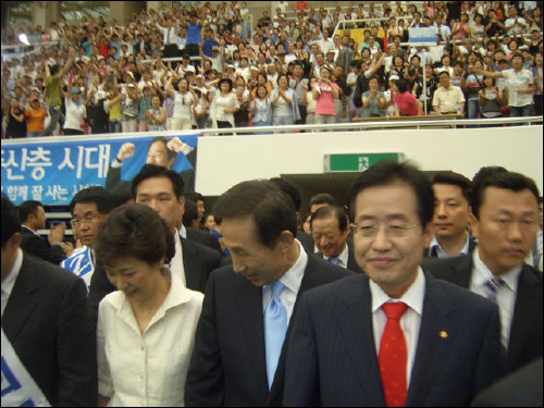 2007년 대선을 앞두고 그해 여름 울산에서 열린 한나라당 대선 후보 유세에서 당시 박근혜 후보와 이명박 후보, 홍준표 후보가 울산종하체육관에 입장하고 있다. 이명박 후보는 울산시민들에게 자신에게 쏟아진 다스 소유주 등 의혹에 이를 부인하며 믿어달라고 했다.