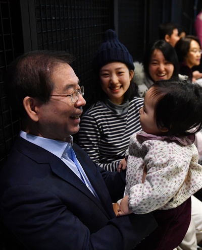 박원순 서울시장(왼쪽)이 26일 오전 시청에서 열린 ‘82년생 김지영에게 듣는다’ 타운홀 미팅에서 한 참석자가 데려온 아기를 안아보고 있다. 
