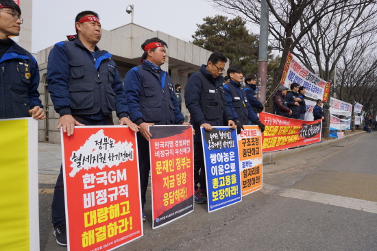 한국GM 비정규직지회 노동자들이 27일 군산시청 앞에서 열린 결의대회에서 피켓을 들고 참석했다.