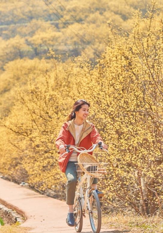 배우 김태리가 의성 산수유마을에서 자전거를 타고 있다.
