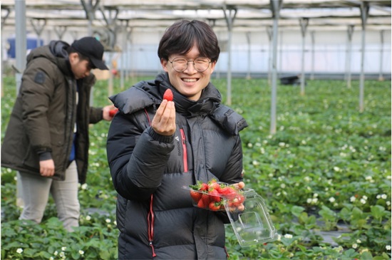 연수단 성기윤(24, 단국대 녹지조경학) 씨가 가온들찬빛농장에서 직접 딴 딸기를 들고 웃고 있다.
