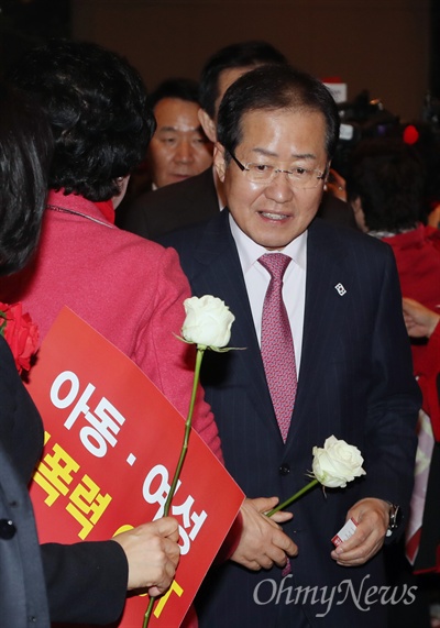 자유한국당 홍준표 대표가 6일 오후 서울 여의도 중소기업중앙회 그랜드홀에서 열린 제1차 자유한국당 전국여성대회에 입장하며 미투 운동을 상징하는 흰 장미를 받아들고 있다. 