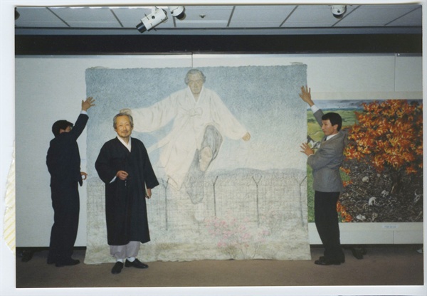 1991년 호암갤러리에서 열린 '임옥상 초대전'에 와서, 임옥상 작가가 자신을 그린 <하나됨을 위하여>앞에 서 있는 문익환 목사