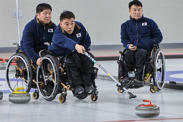  평창동계패럴림픽에 출전하는 휠체어컬링 한국 국가대표 선수들. 투구하는 차재관 선수의 휠체어를 이동하 선수가 잡아주고 있다.