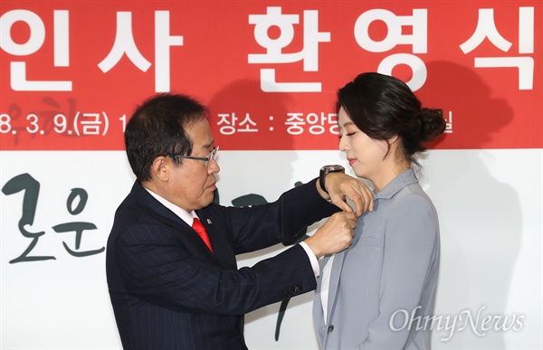 자유한국당 홍준표 대표가 9일 오전 서울 여의도 당사에서 입당한 배현진 전 MBC 앵커에게 태극기 배지를 달아주고 있다.