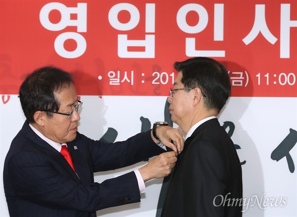 길환영에게 태극기 배지 달아주는 홍준표  자유한국당 홍준표 대표가 9일 오전 서울 여의도 당사에서 입당한 길환영 전 KBS 사장에게 태극기 배지를 달아주고 있다.