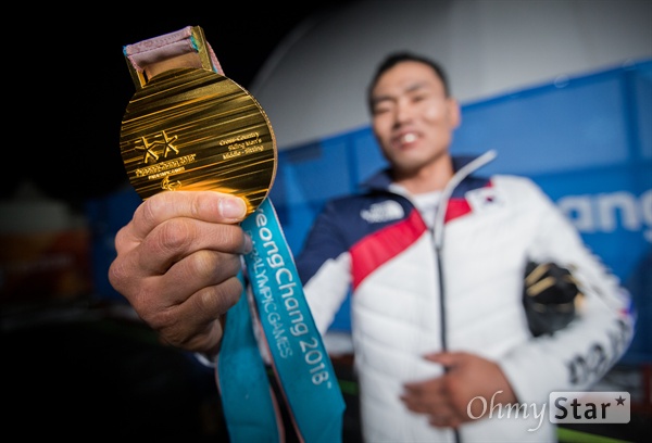  노르딕스키 신의현 선수가 17일 오후 강원도 평창 올림픽메달플라자에서 열린 크로스컨트리 남자 7.5km 좌식 부문 수상식에서 받은 금메달을 기자들에게 보여주고 있다.