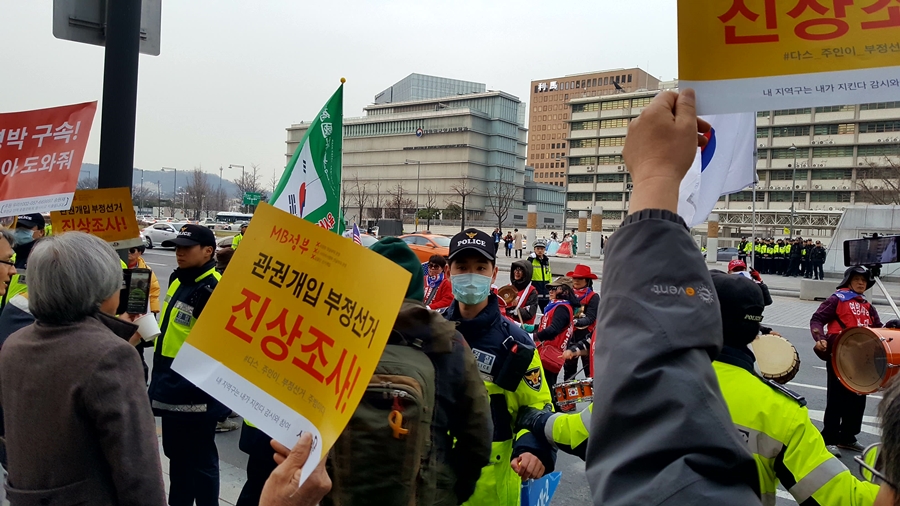 17일 서울 종로구 광화문 세종문화회관 앞에서 열린 '이명박 구속 촛불문화제' 참가자들과 근처를 지나던 태극기 집회 참가자들이 대치하고 있다. 