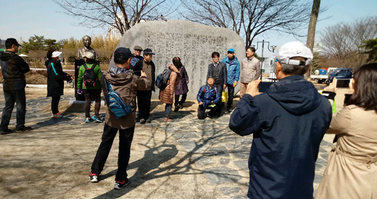 수성못 둑에 세워져 있는 상화 시비 앞에서 상동마을여행 김두현 대표(앉은이)의 해설을 듣고 있는 '두산동 상동 마을 답사' 참가자들