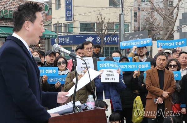 정봉주 전 의원이 18일 오전 서울 마포구 연남동 연트럴파크에서 서울시장 출마선언을 하는 동안 정 전 의원의 지지자들이 '정의가 이긴다'라고 적힌 팻말을 들고 있다. 
