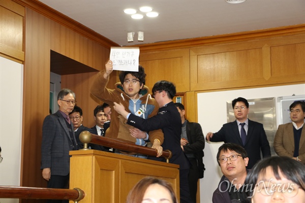 19일 열린 대구시의회 임시회에서 기초의원 4인 선거구를 2인 선거구로 쪼개는 안이 한국당 시의원들에 의해 통과되자 방청석에 있던 시민단체 회원이 손피켓을 들고 항의하다 청원경찰에 의해 끌려나가고 있다.