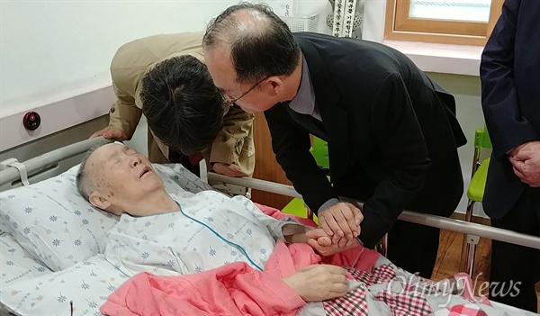 20일 오후 박종철 열사의 아버지인 박정기(90)씨가 입원한 부산의 한 요양병원을 찾은 문무일 검찰총장이 박씨의 손을 잡고 쾌유를 빌고 있다. 