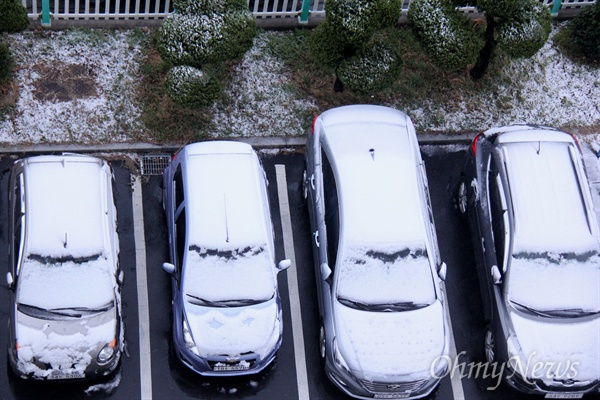 춘분인 21일 아침 경남 창원지역에 눈이 내려 한 아파트 주차장의 차량에 쌓여 있다.