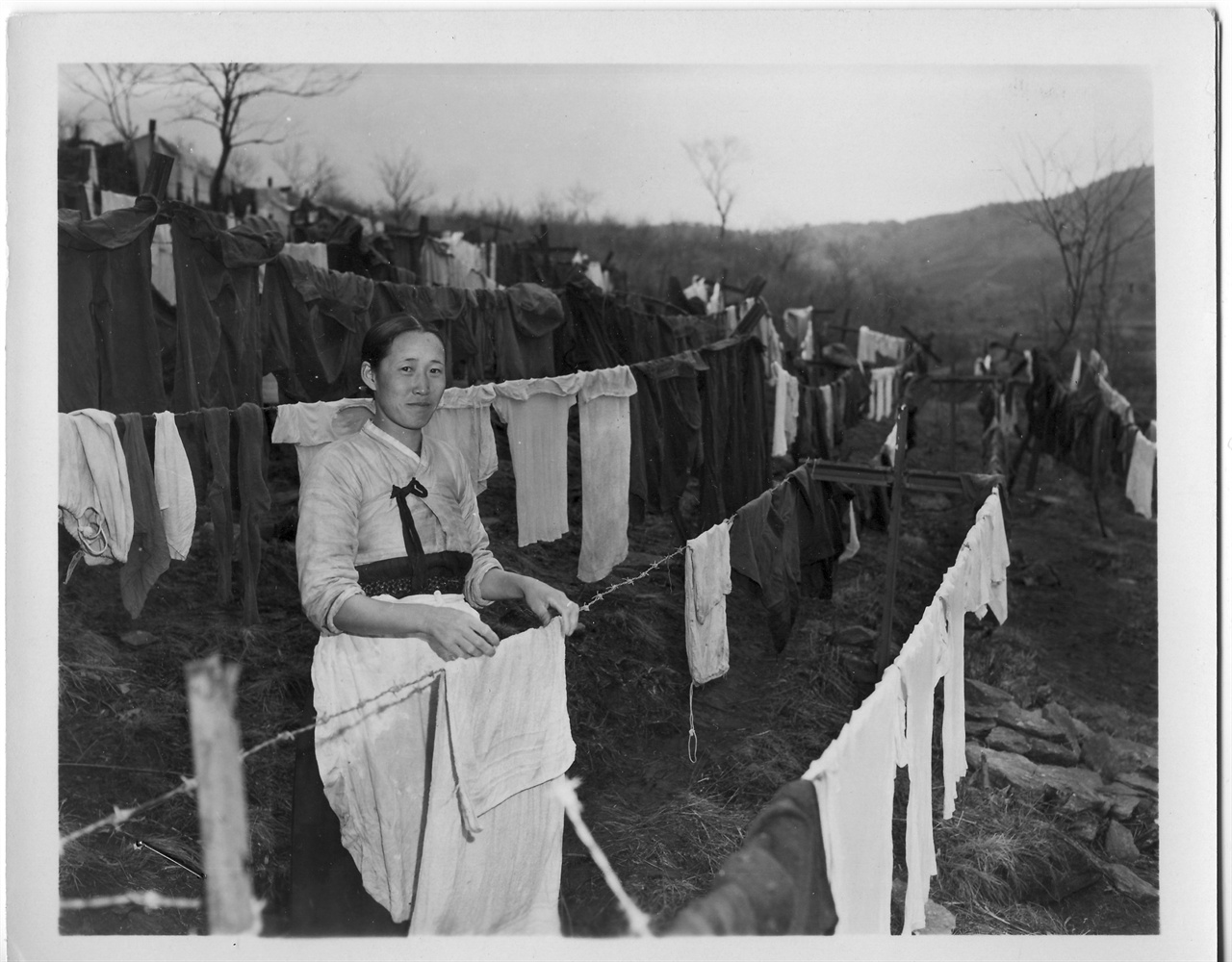 1954. 3. 3. 한국의 한 여인이 미군부대 근처에서 세탁물을 널고 있다.