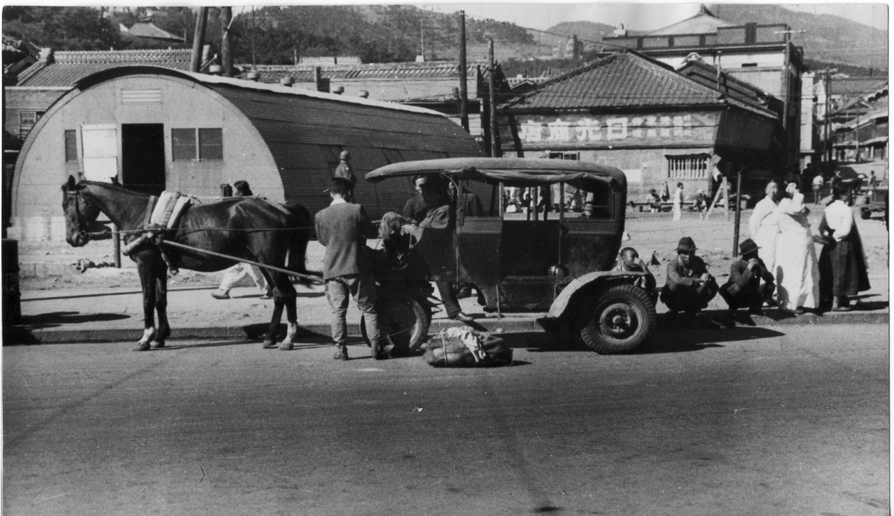 1948. 8 부산, 자동차가 귀한 부산거리에 택시 대신에 택시 모형을 본뜬 마차가 운행하고 있다.