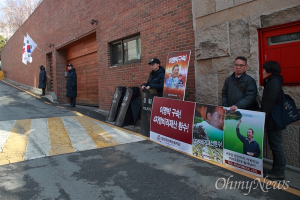 이명박 전 대통령 자택 앞 1인 시위 나선 민중민주당 "이명박을 구속하라" 법원이 이명박 전 대통령의 구속 전 피의자 심문(영장실질심사)을 서류심사로만 진행하기로 한 22일 오전 서울 강남구 이 전 대통령 자택 앞에서 민중민주당(환수복지당) 당원이 4자방비리재산 환수와 이 전 대통령의 구속을 촉구하는 1인 시위를 벌이고 있다.