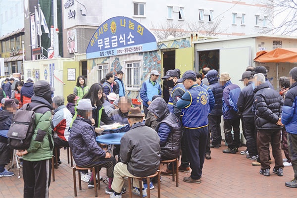 18일 오전 11시 이웃사랑나눔회가 창원 마산역 앞 무료급식소에서 밥을 나눠주고 있다.