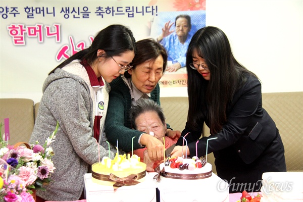 일본군위안부 피해자 김양주 할머니가 올해 95세 생일을 맞아, 23일 저녁 창원 마산우리요양병원에서 열린 잔치에서 이경희 대표와 학생들이 함께 케이크를 자르고 있다.