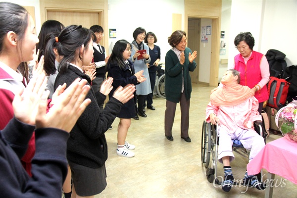 일본군위안부 피해자 김양주 할머니가 올해 95세 생일을 맞아, 23일 저녁 창원 마산우리요양병원에서 열린 잔치에서 할머니가 복도로 나오자 학생들이 박수를 치고 있다.