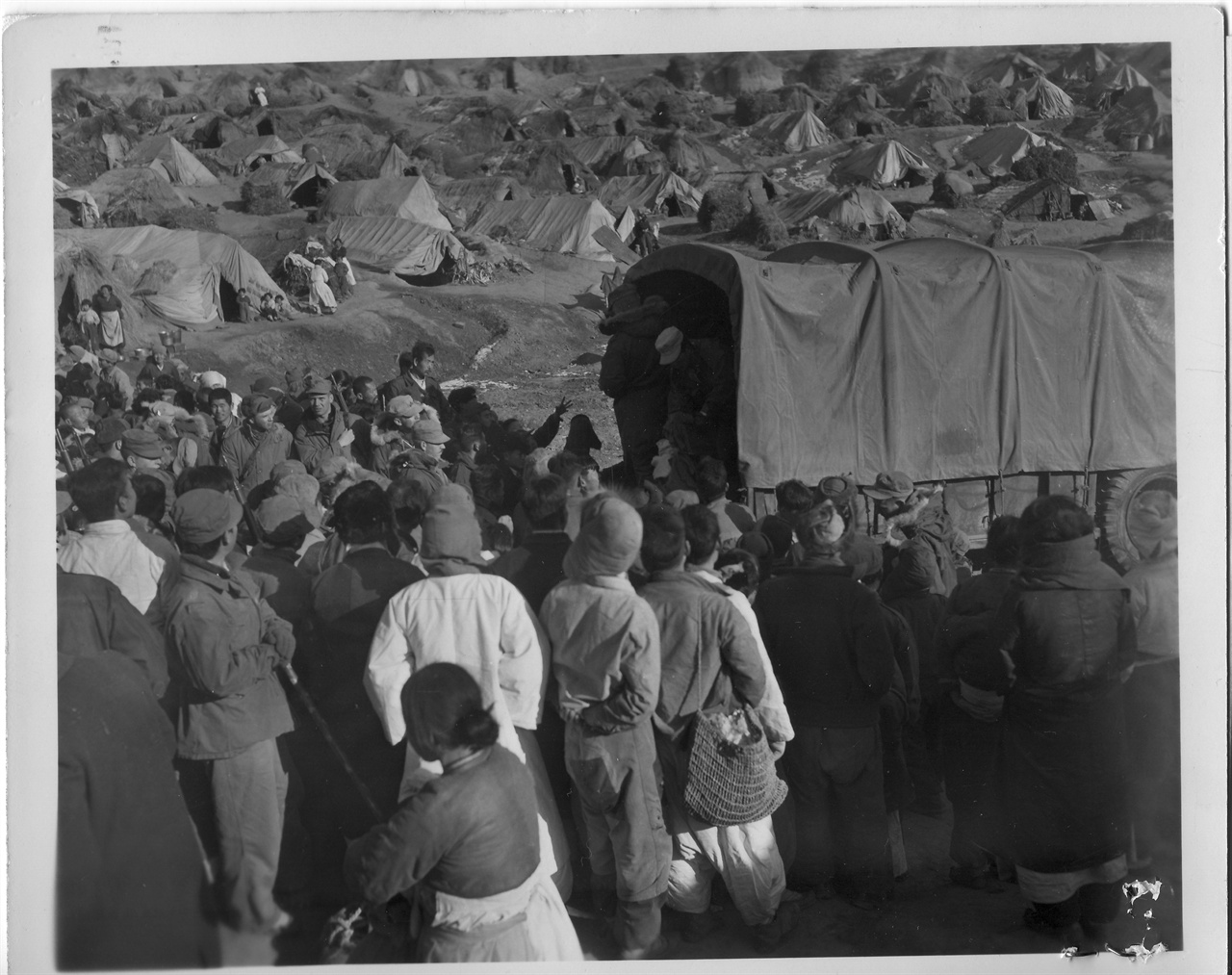 1953. 1. 29. 파주 금촌, 피란민촌에 미군 구호차가 오자 피란민들이 몰려들고 있다.