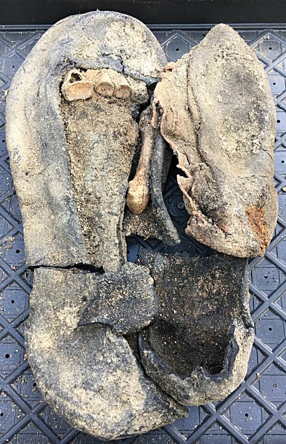 발굴 18일 째. 엄마의 왼발 신발에 담긴 발뼈와 아이의 고무신(오른 쪽)