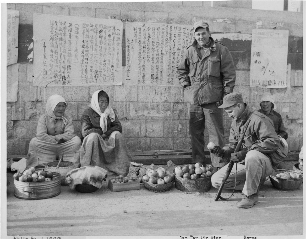 1950. 11. 20. 원산, 유엔군들이 노점에서 사과를 사고 있다.