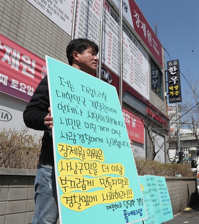 25일 부산 사상구 장제원 자유한국당 의원 사무실 앞에서 전국경찰 온라인 모임 폴네티앙 회장인 유근창 경남경찰청 경위가 장 의원의 사과를 요구하는 1인 시위를 하고 있다. 장 의원은 최근 경찰의 김기현 울산시장 측근 비리 수사와 관련해 야당 탄압이라며 경찰을 "정권의 사냥개가 광견병까지 걸려 정권의 이익을 위해서라면 닥치는 대로 물어뜯기 시작했다. 미친개는 몽둥이가 약"이라고 비난했다.