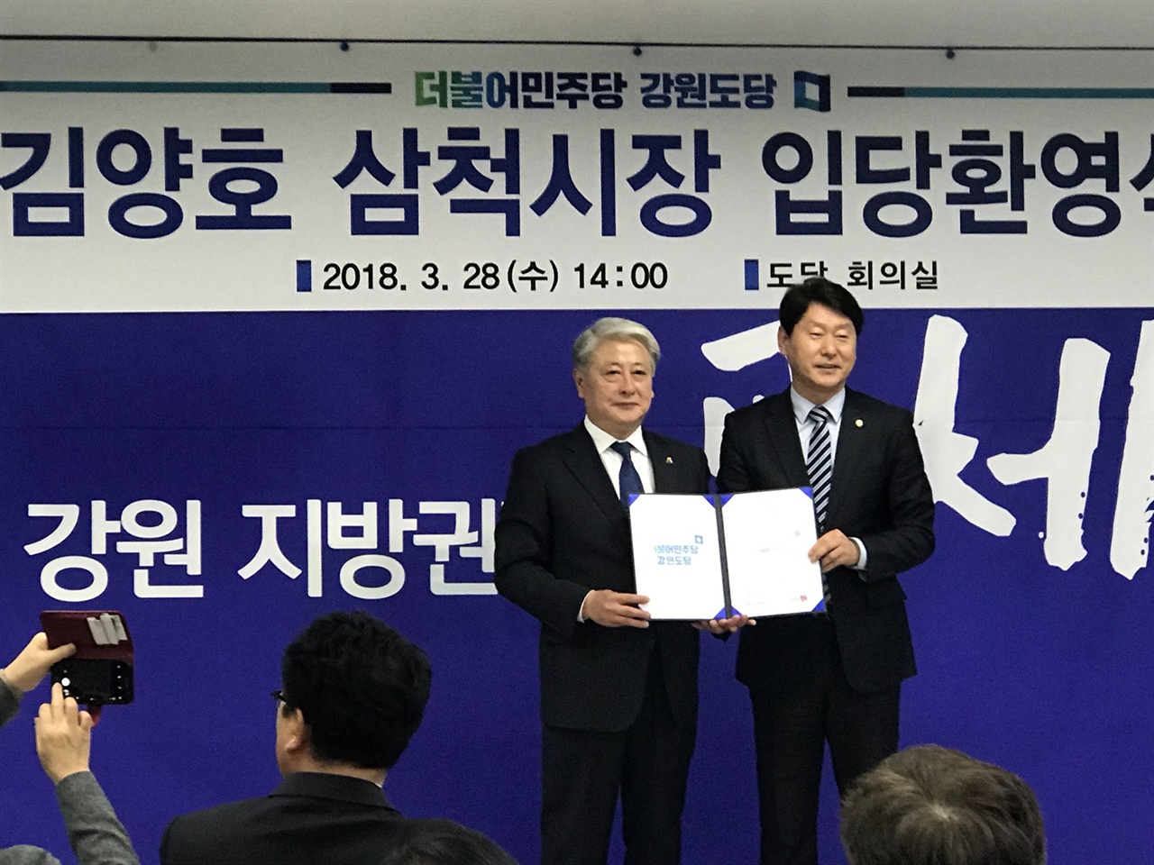 김양호 삼척시장이 더불어민주당 강원도당 회의실에서 민주당 입당증을 교부받고 기념촬영을 하고 있다.