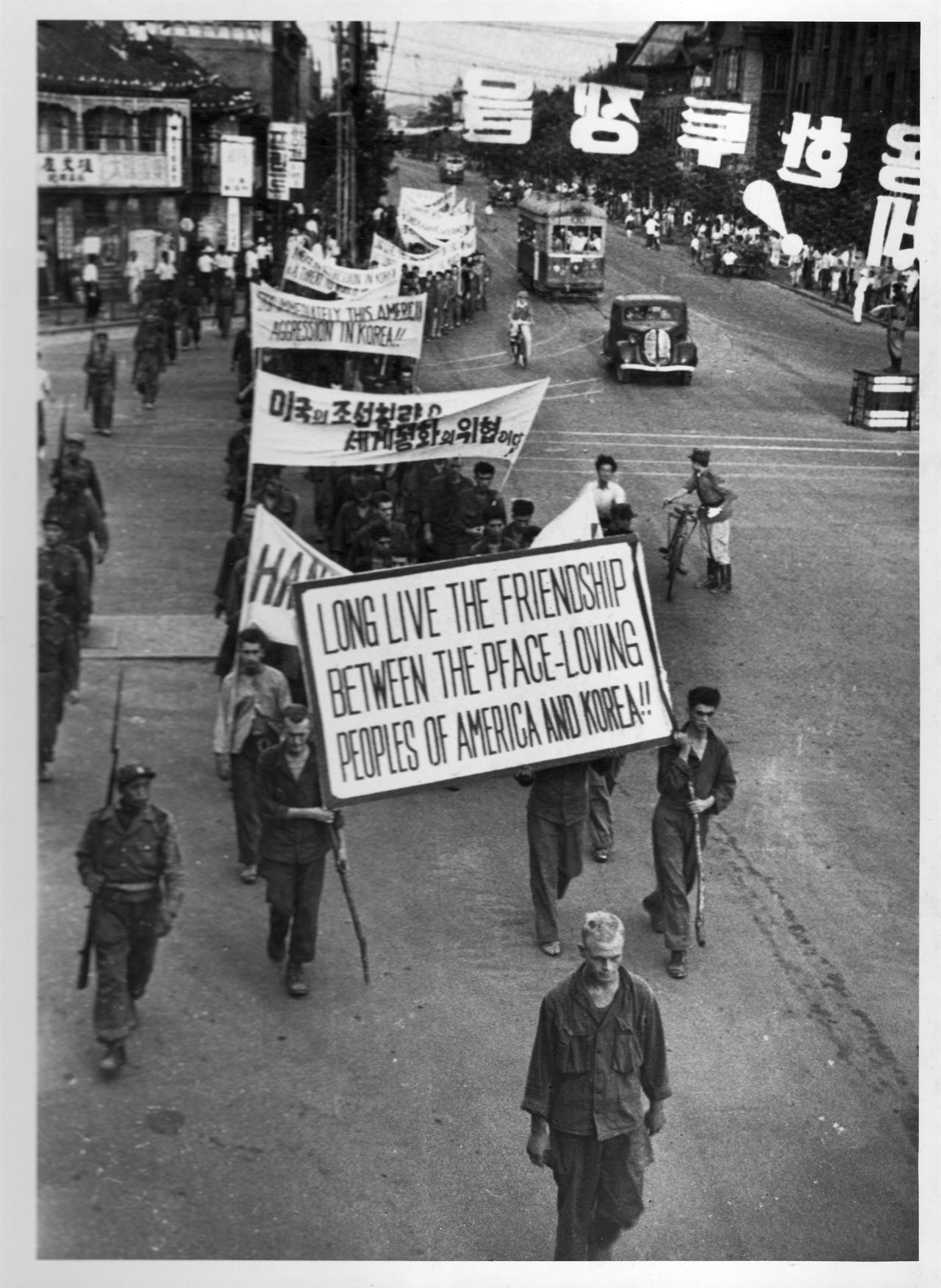 1950. 8. 서울. 유엔군 포로들이 반전 플래카드를 들고 시가행진을 하고 있다.