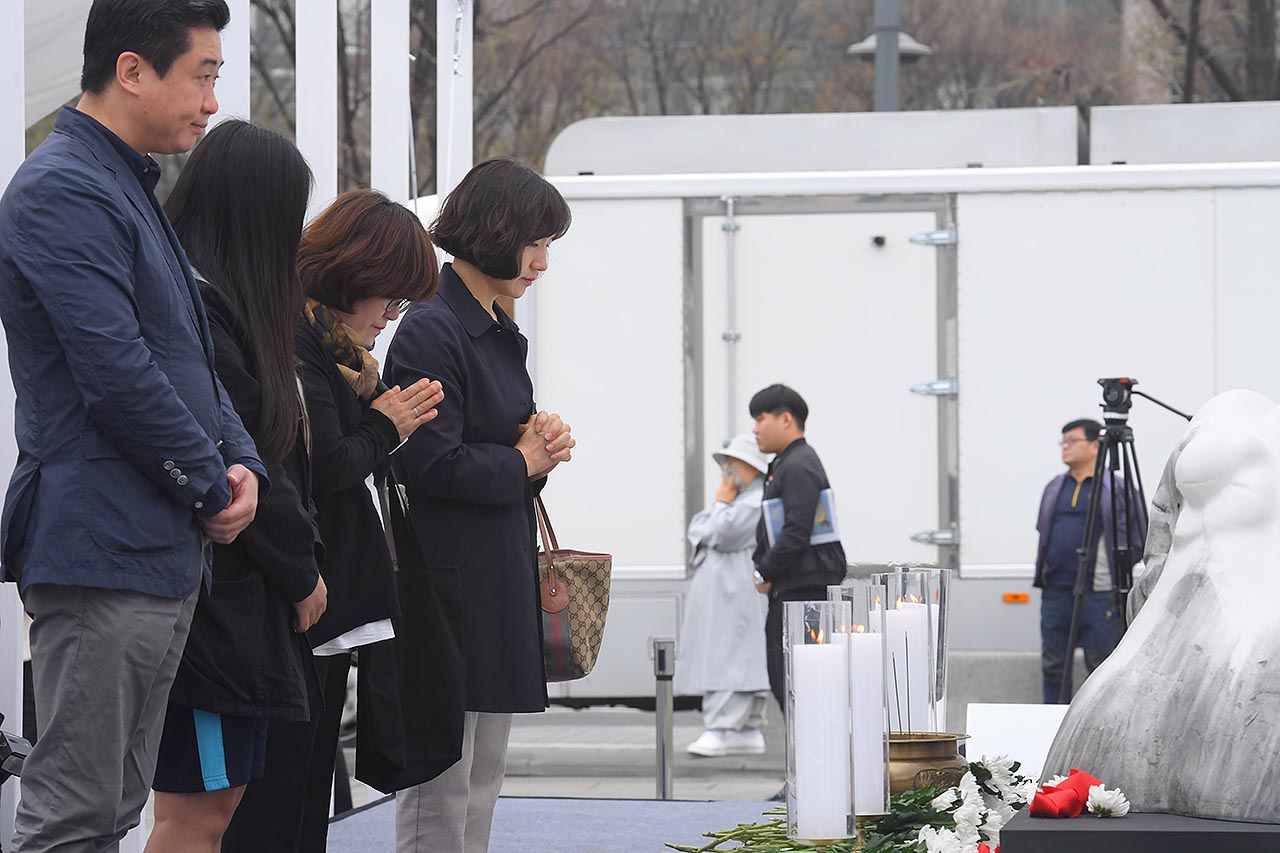 제주 4.3 70주년 광화문 추념식이 3일 오전 서울시 종로구 광화문광장에서 열리고 있는 가운데 추모객들이 행사장 한켠에 마련된 추모공간을 찾아 희생자들을 추모하며 고개를 숙이고 있다. 2018.04.03