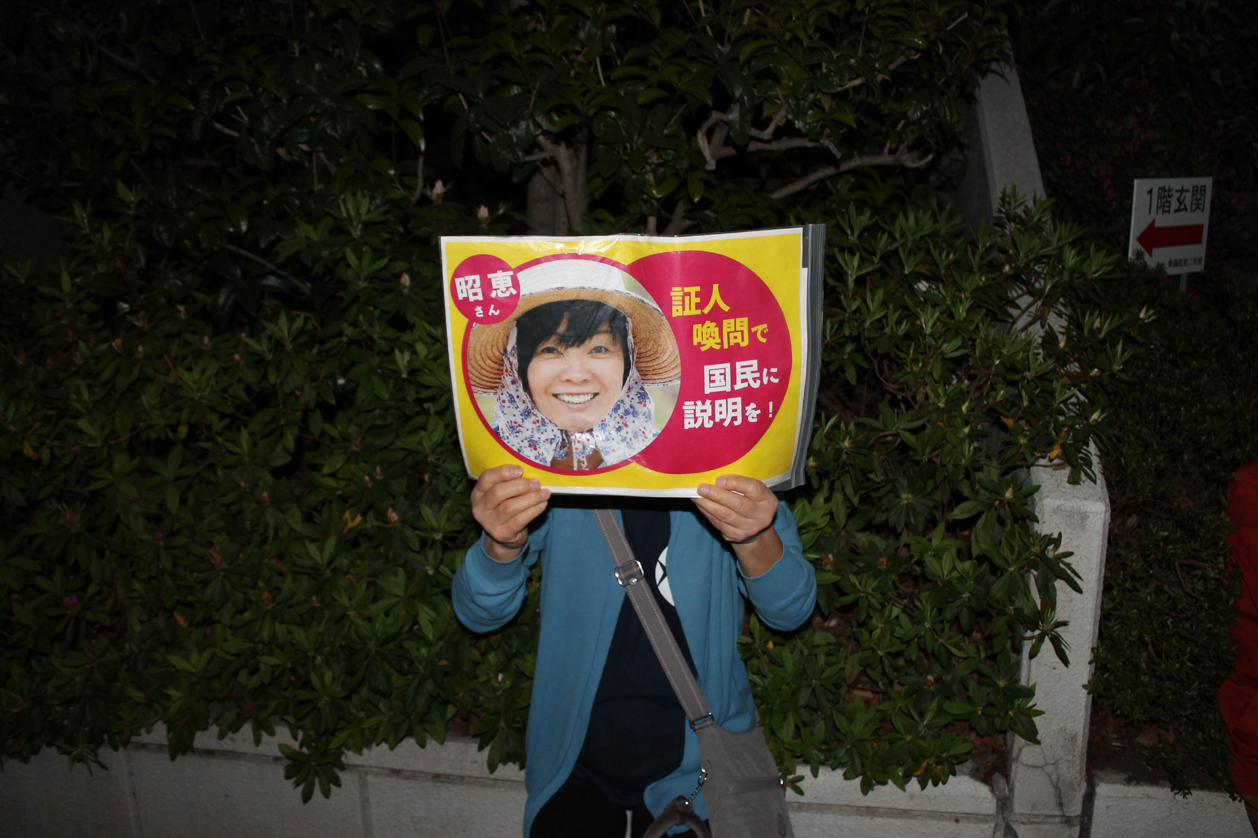 6일 저녁 도쿄 치요다구 일본 총리 관저 앞 시위에서 한 참가자가 아베 총리 부인 아키에씨의 국회 증인 소환을 요구하는 손팻말을 들고 있다.