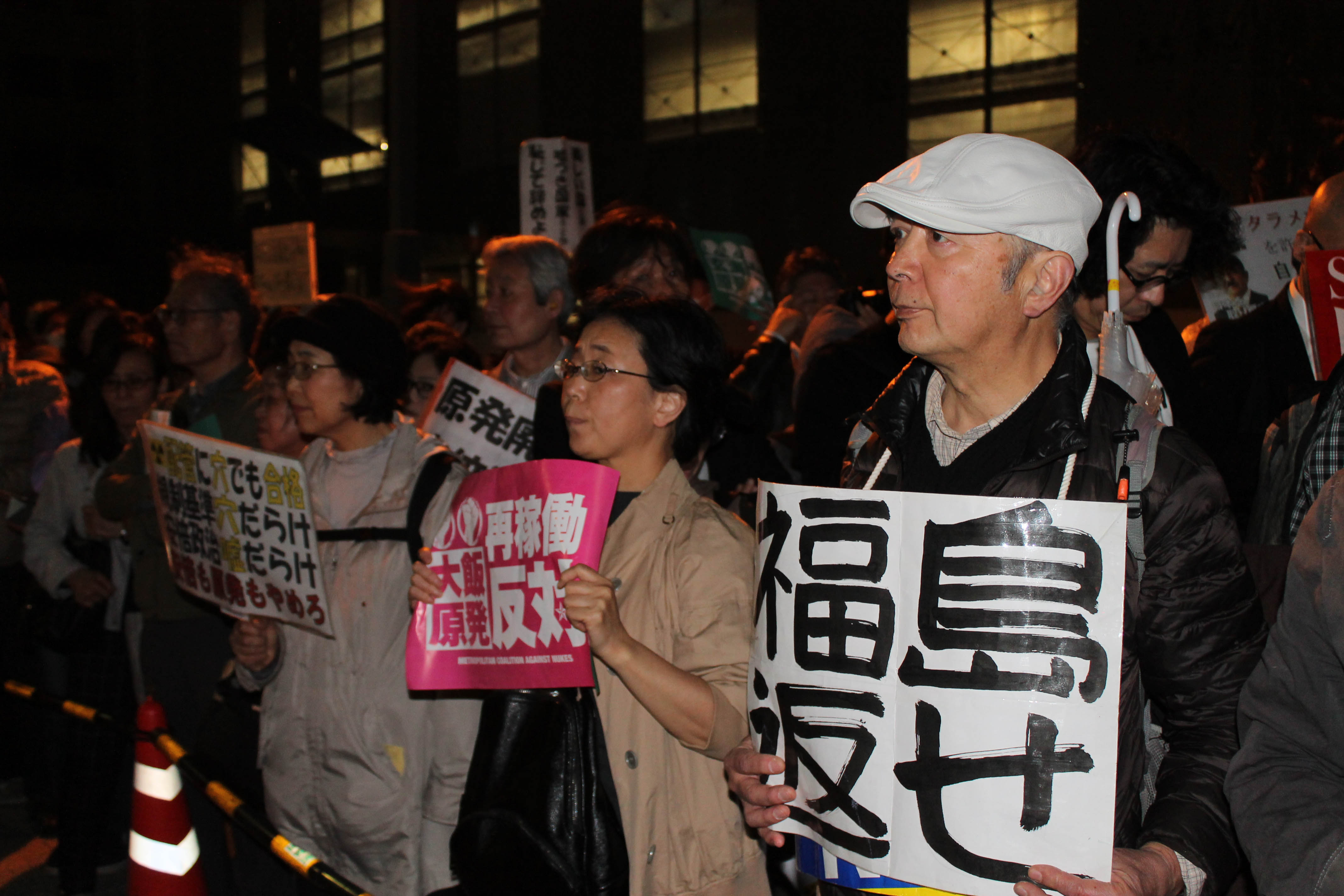 6일 저녁 도쿄 치요다구 일본 총리 관저앞 시위에서 참가자들이 '원전 재가동 반대'를 외치는 팻말을 들고 구호를 외치고 있다.