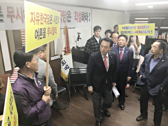 김석기 국회의원이 10일 자신의 사무실에서 항의하는 최양식 시장 지지자들 사이로 빠져 나가고 있다.