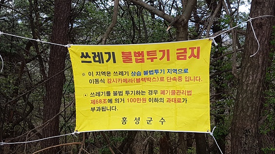 홍성군의 한 지방도 인근에는 쓰레기 불법투기를 경고하는 현수막이 붙여져 있다. 