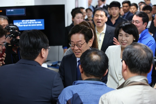  이재명 후보가 경선 승리 직후 선거 사무실을 방문, 선거 사무소 관계자들과 악수를 하고 있다. 