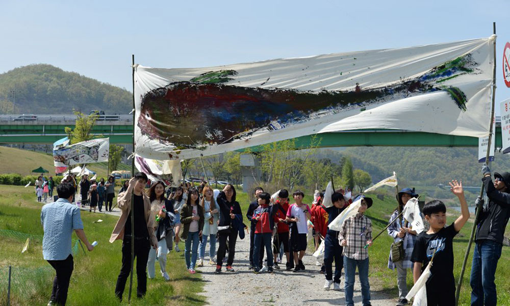 참석자들이 광목천에 그린 대형 물고기 그림과 깃발을 들고 공주보로 이동하고 있다.