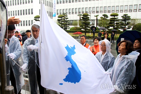  박종훈 경남도교육감과 송기민 부교육감, 김영만 경남평화회의 상임의장, 이경희 하나됨을위한늘푸른삼천 이사장이 23일 경남도교육청 국기게양대에 한반도기를 매달고 있다.